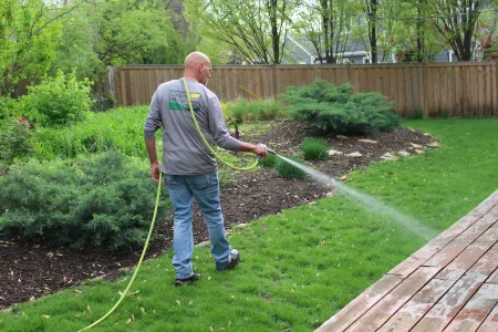 tech spraying green lawn