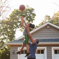 father and daughter playing basketball outside