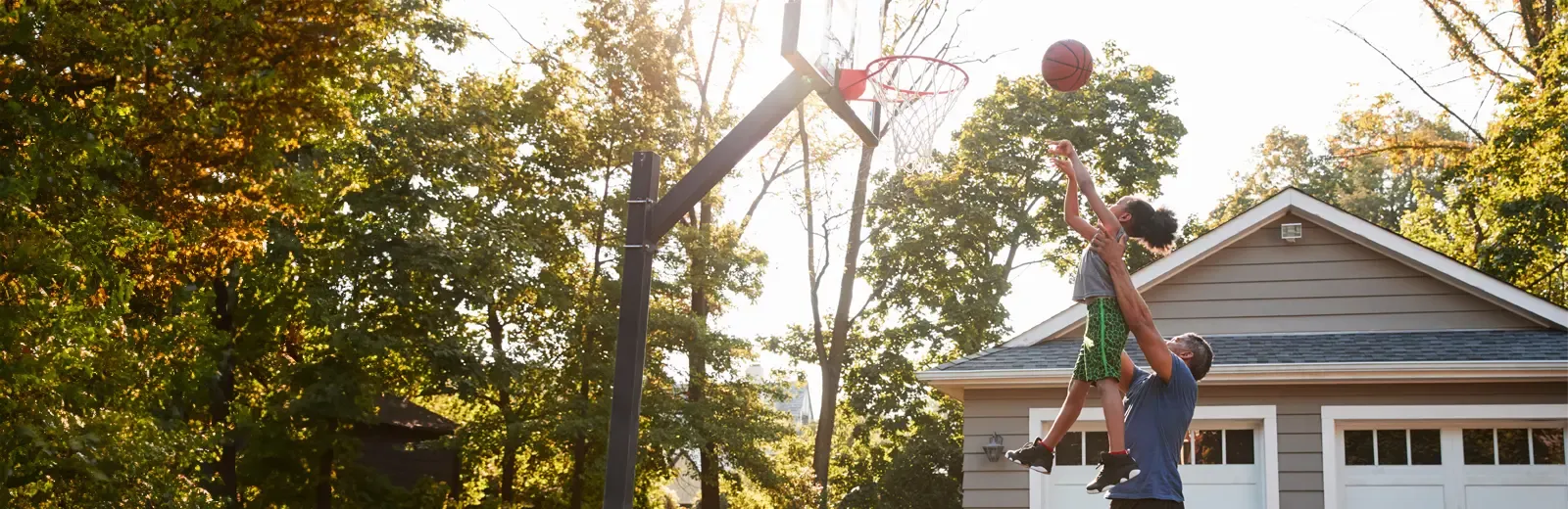 father and daughter playing basketball outside